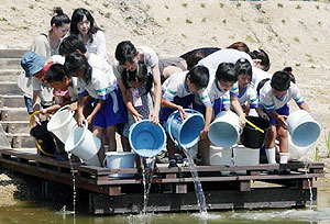 ため池にメダカを放流する子どもたち＝鯖江市米岡町で
