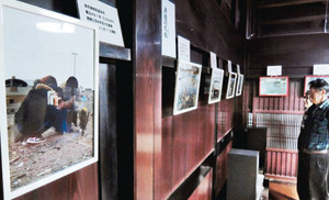 東日本大震災の被災地で本谷さんが撮影した写真が並ぶ古民家＝金沢市花園八幡町で