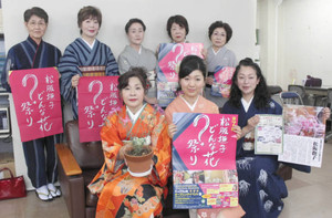 「松阪撫子どんな花？祭り」のポスターを手に来場を呼び掛ける「ミズ・ネットワーク松阪」のメンバーら＝松阪市役所で