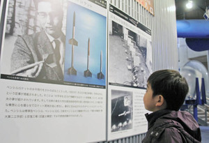 日本の宇宙開発の父・糸川英夫博士のパネルを見上げる子ども＝坂井市のエンゼルランドふくいで